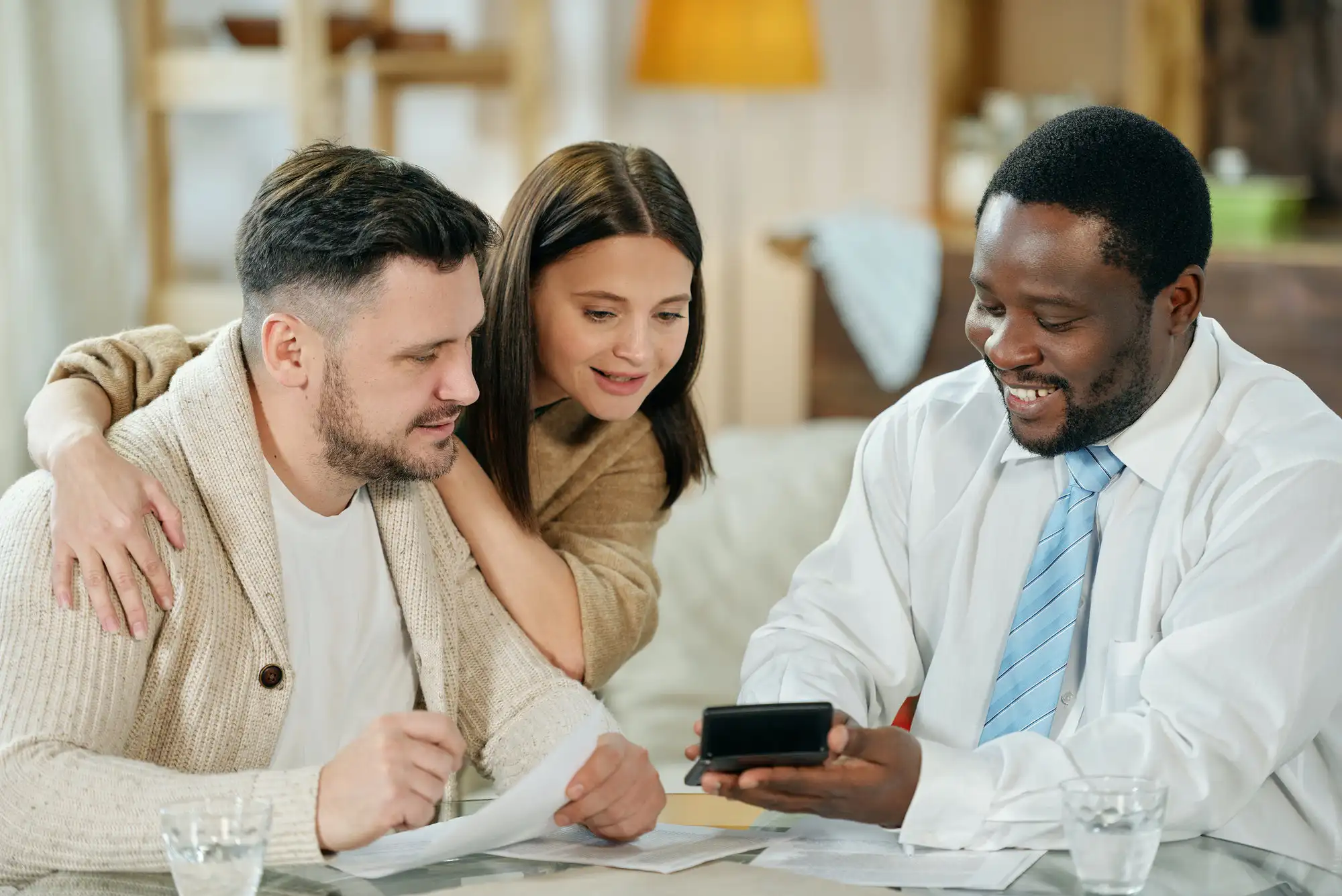 content man advising young couple on home loan